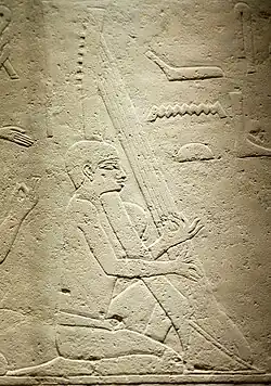 Harpist playing shovel harp⁷