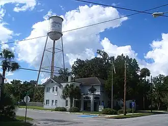 Two-story corner building with a water tower behind it