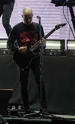 Josh Middleton holding an electronic guitar during a live performance