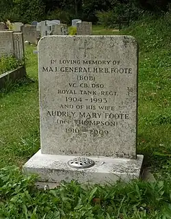 A granite headstone among other headstones