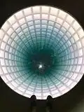 Hollow Earth by Glenn Kaino is an illuminated, glass-covered hole that creates the illusion of a tunnel descending deep into the Earth
