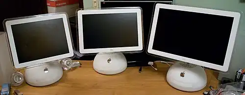 Three white computers arrayed side-by-side; they are identical save for their screens of differing sizes, arranged from smallest to largest.