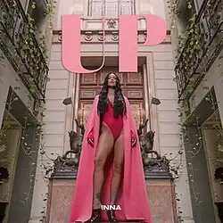 Cover of Inna's single showing the singer wearing a pink outfit while standing in a courtyard