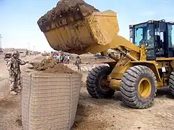 Iraqi Army engineers fill a section of four-foot HESCO MIL with a wheel loader