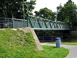 Iron bridge over the River Aire linking the mills and houses of Saltaire with Roberts Park