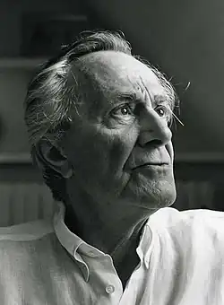 Black-and-white photo of man wearing a white shirt with his gaze directed slightly upward