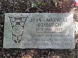 Flat grey granite marker engraved with Roxburgh's name and a CAHA logo
