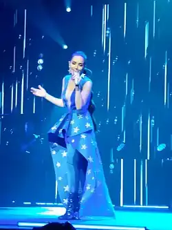 Natalia on stage in a blue dress.