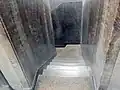 Stairs behind elevator to basement.