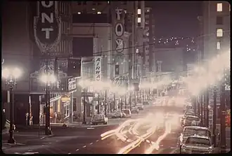 A time lapse photo of a street in portland at night. It shows the Fox Theatre and surrounding buildings with their marquee lighiting off.