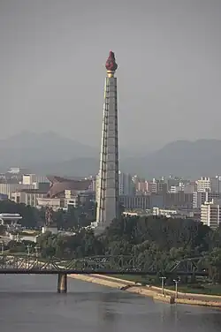 Very tall plinth with a statue of a flame in a cauldron on top