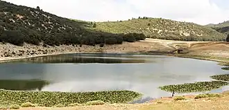 A body of water surrounded by hills in the background.