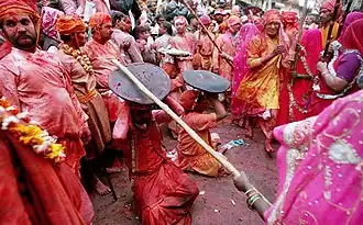 In the Braj region of North India, women have the option to playfully hit men who save themselves with shields; for the day, men are culturally expected to accept whatever women dish out to them. This ritual is called Lath Mar Holi.[100]