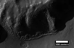 Layers in mantle deposit, as seen by HiRISE, under the HiWish program. Mantle was probably formed from snow and dust falling during a different climate. Location is Thaumasia quadrangle.