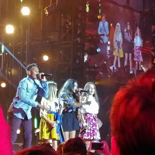 Erza (right) performing as a member of the group Kids United in July 2017.
