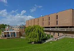 A photo depicting the outside of the library building for the University of Bradford, the sky is blue and the grass is green outside of the library in a close by park.