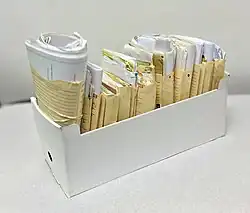 Lloyd George envelopes stacked in box: compact, with insertion cards and folded hospital letters