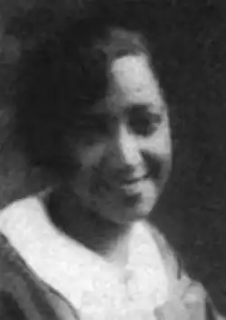 A smiling young Black woman with dark hair styled with a side part