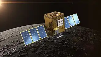 A small rectangular spacecraft is above the Moon’s surface, with solar panels on both sides.