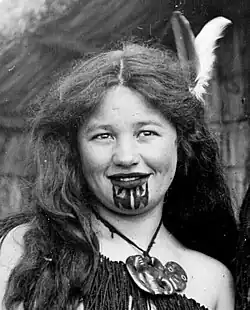 young Maori girl with chin tattoo in traditional dress.
