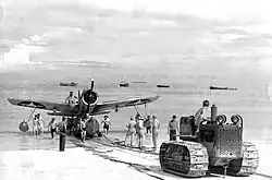 US Navy Marine tractor pulls Vought OS2U Kingfisher on Funafuti Beach in 1943 at Naval Base Funafuti