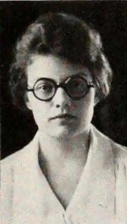 A young white woman wearing glasses with round frames