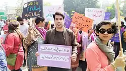 A young man holds a sign.