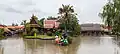 Traditional Thai wooden houses and two Thai child's dolls at Ayothaya floating market, another renowned floating market in Thailand