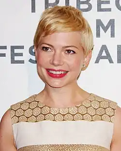 A head shot of Michelle Williams as she grins.