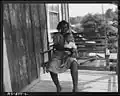 Mrs. Aron Conway and baby swinging on porch of their home, 1946
