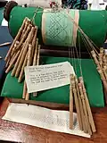 Mundillo bobbin lace roller pillow and bobbins with pricking, from Puerto Rico