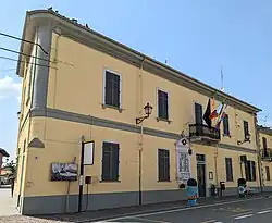 Municipio di Ronsecco, un edificio a due piani di colore giallo, con bandiere al balcone.