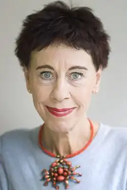 Woman with short hair wearing a crab-shaped necklace