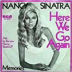 Black and white cover art photo of Nancy Sinatra on one elbow in a white dress. The border is purple as is some of the captioning. Caption says Nancy Sinatra in black. Side captions detail the record label and the song name in purple. The bottom caption has the B-side song name, "Memories".