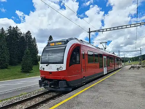 Red and white train next to station platform