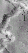 Close view of the Nanedi Valles, as seen by Mars Global Surveyor (enlargement of the previous image). Arrow points to a small channel that formed after the main valley.