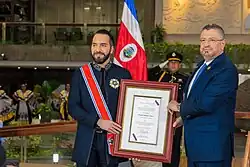 Nayib Bukele, wearing the sash of the National Order of Juan Mora Fernández, and Rodrigo Chaves holding a document