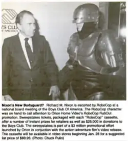 Newspaper photo of former US president Richard Nixon shaking hands with someone dressed as RoboCop