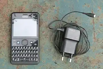 Nokia Asha 210 with Facebook button and French charger.