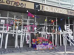 Multiple crosses and candles are located at the entrance of the metro station.