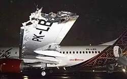 an aircraft disabled on a runway in the dark, with evacuation slides deployed