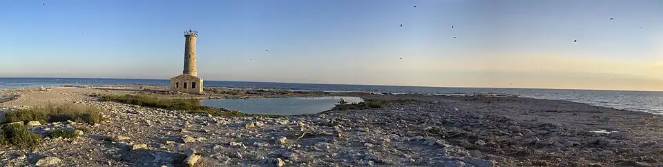 Bare rock island with ruined lighthouse and Lake Erie in the background