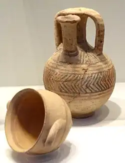 Two pots: one small bowl, lying on its side, and a jar with a spout offset from its centre.