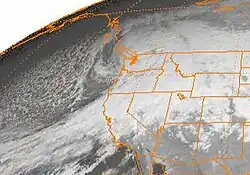 Satellite image of the Western United States, Western Canada, and the Pacific Ocean, with the states of the US shown in orange lines. The Inauguration Day storm is visible as a comma-shaped formation of clouds over the state of Washington.