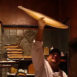 Tossing pizza dough to stretch it