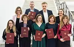 All nine "Together" politicians posing in Sejm holding the National Electoral Commission certification