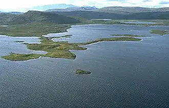 View of the lake with an island in the foreground and mountain range in the background