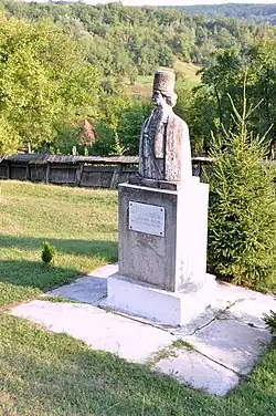 Stone statue with a backdrop of grass and trees