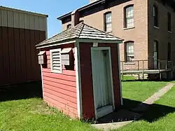 Picture of outhouse with School in background