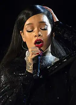 A woman wearing a black dress singing